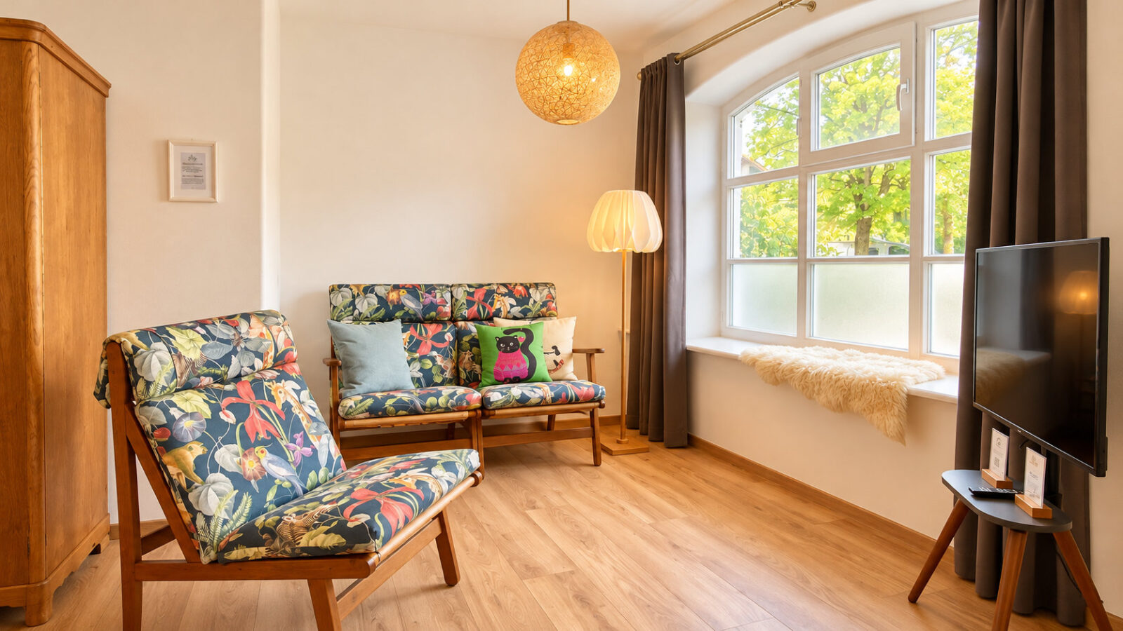 SEEZEIT Ferienwohnungen am Mühlbach – Apartment mit 2 Schlafzimmern: Wohnzimmer mit Sofa, Sessel und Smart-TV