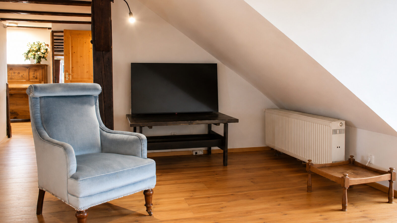 SEEZEIT Zinnmanufaktur – Wohnecke mit Ohrensessel und TV SEEZEIT Ferienwohnung an der Zinnmanufaktur: Wohnecke mit Ohrensessel und TV