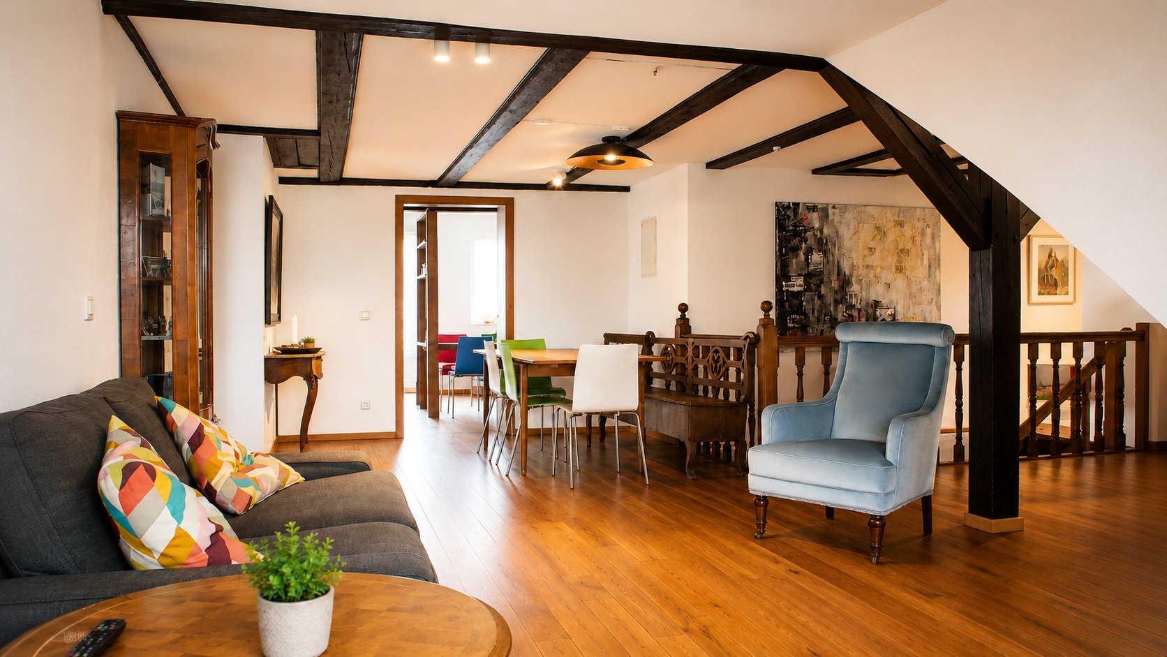 SEEZEIT Ferienwohnung an der Zinnmanufaktur: Wohnbereich mit Sofa und historischen Holzbalken